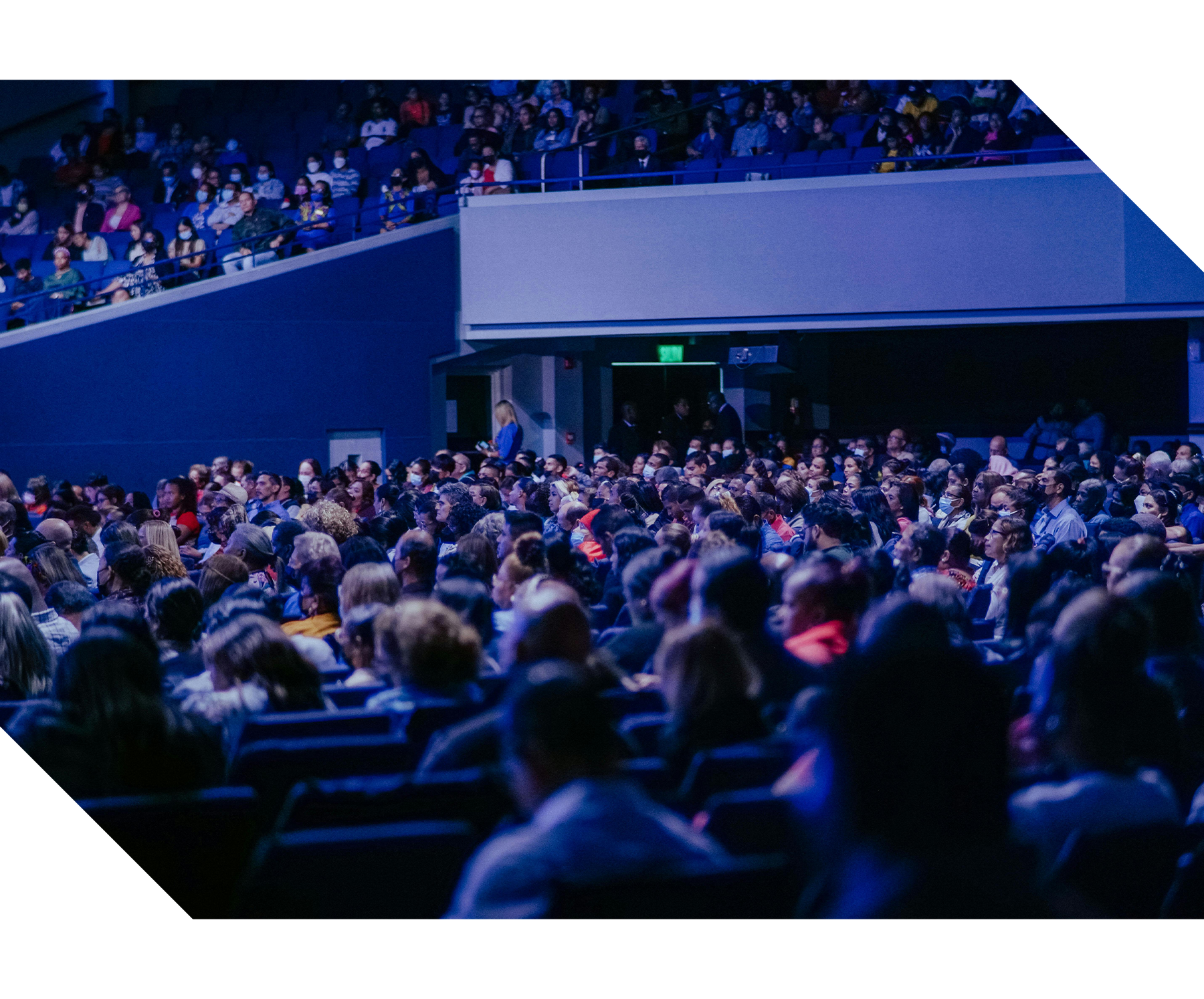 Attendees seated in a conference session listening to a speaker presenting on stage, representing professional conferences, knowledge sharing, networking, and event management services.